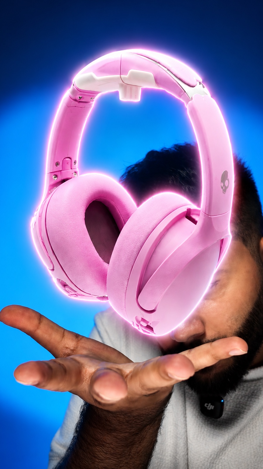 A frame from Saqib's content: pink headphones floating above his open hand