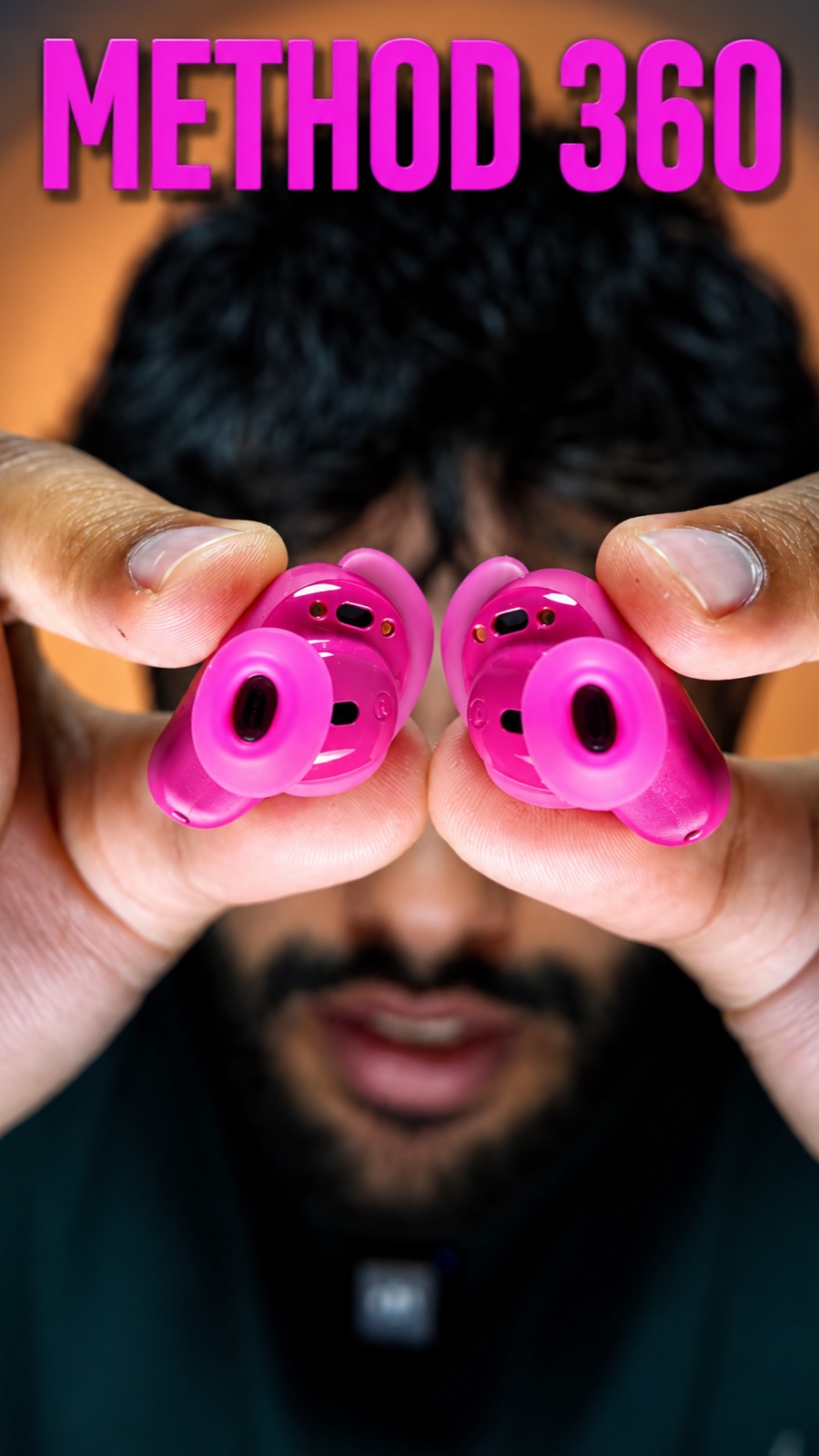 Method 360 earbuds review: Saqib holding two pink earbuds up like binoculars